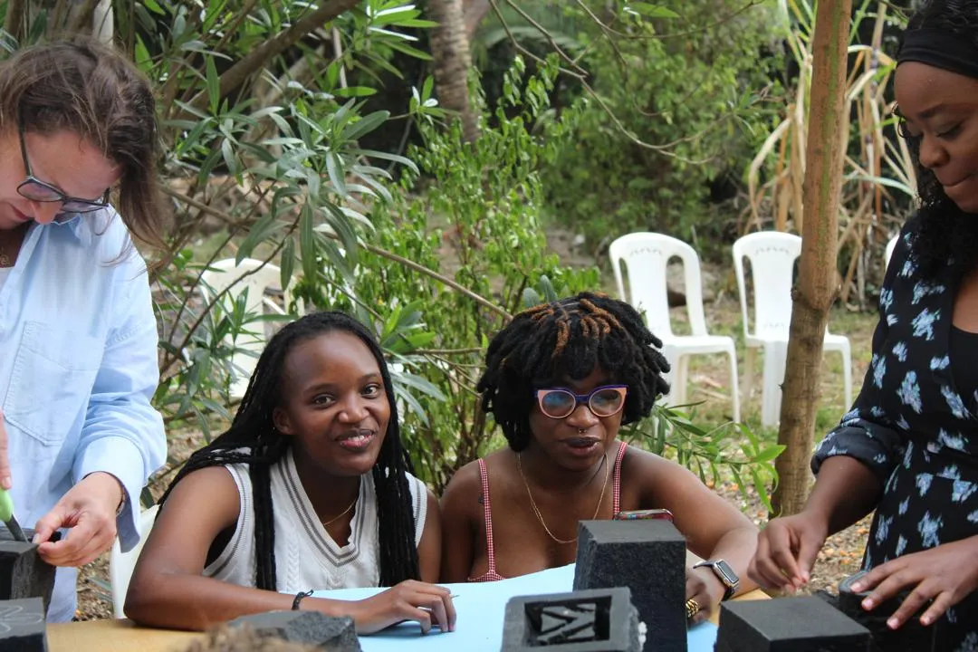 Workshop participants learning around a studio table